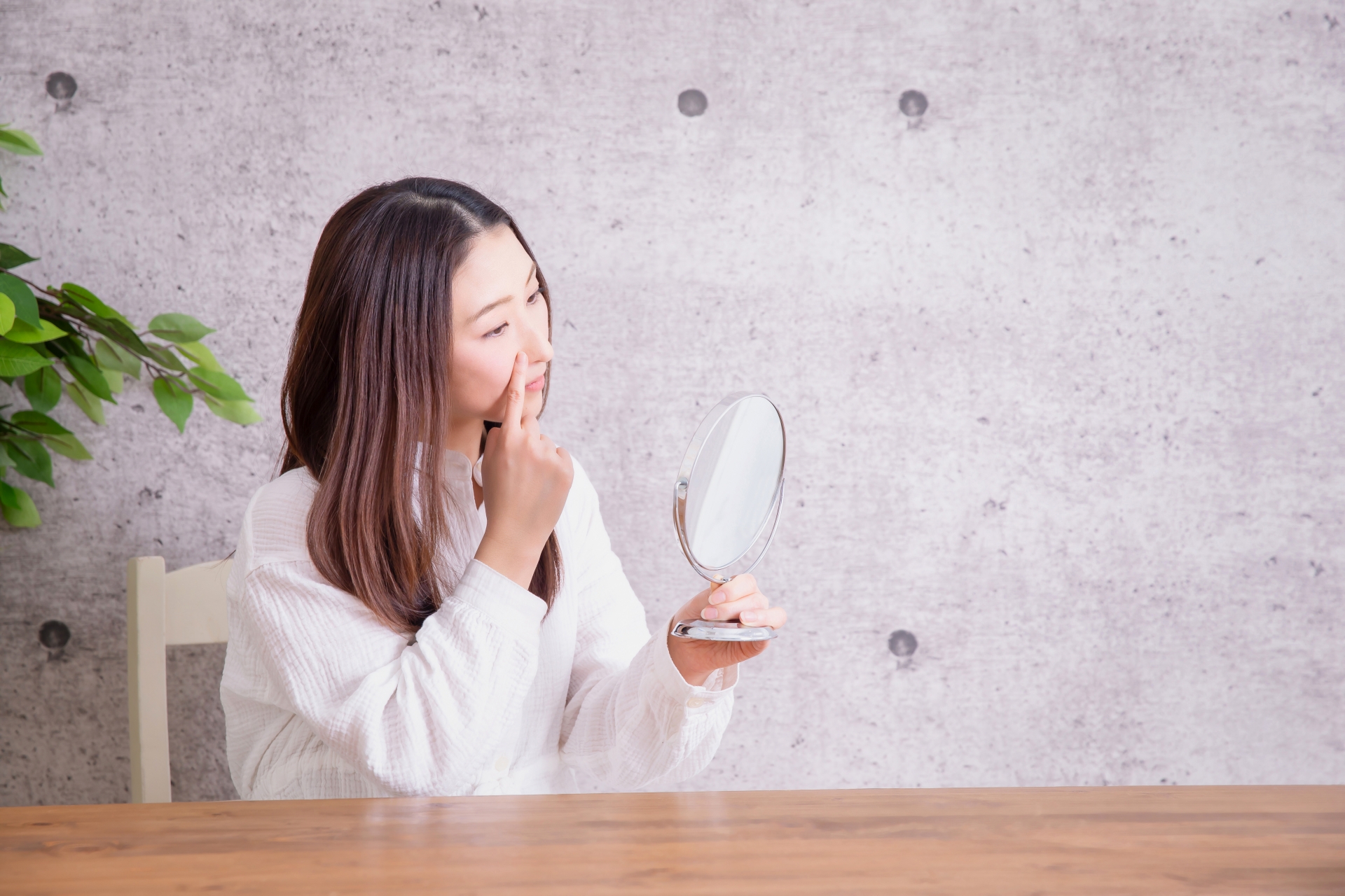 鏡で顔を確認する女性