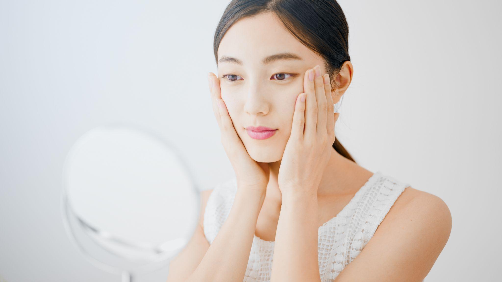 鏡でフェイスラインを確認する女性